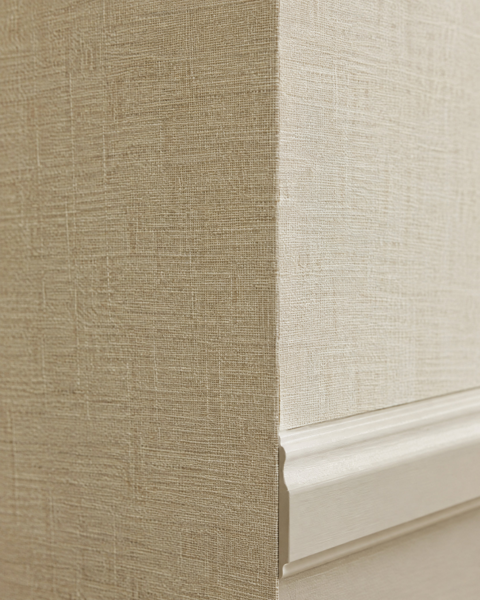 Close-up of linen wallpaper texture and molding edge